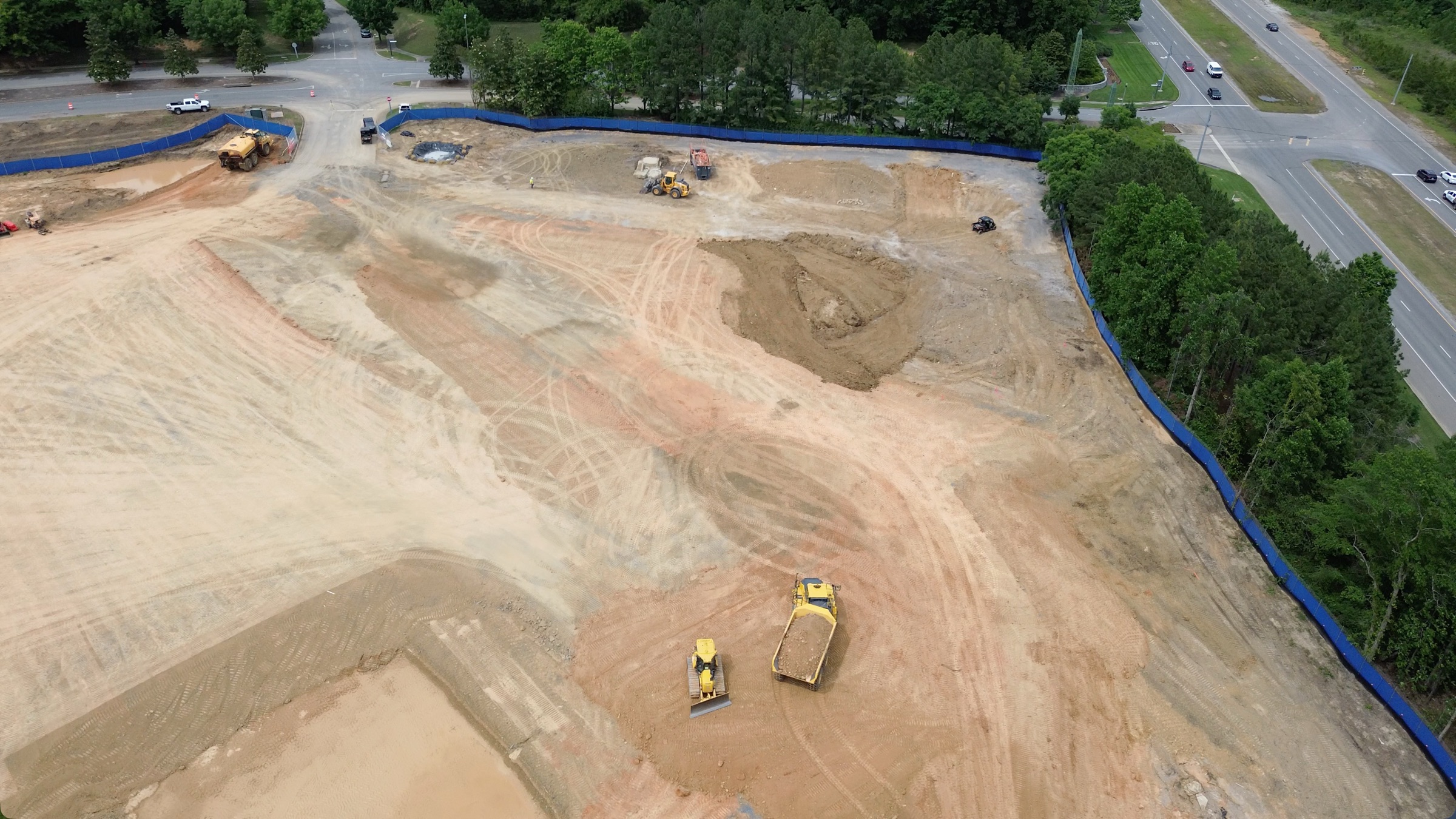 Aerial view of the cleared Nebius construction site in Oxmoor Valley, with earthmoving equipment and blue silt fencing along the perimeter